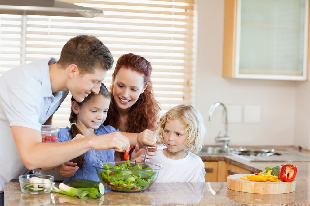 Young family preparing salad together